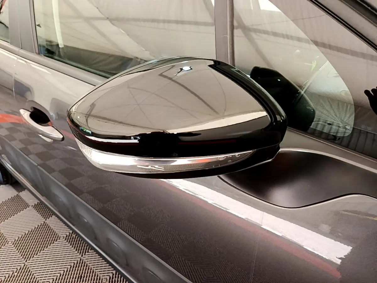 Rétroviseur droit noir brillant avec clignotant intégré sur Citroën C3 gris foncé vue de profil rapprochée.