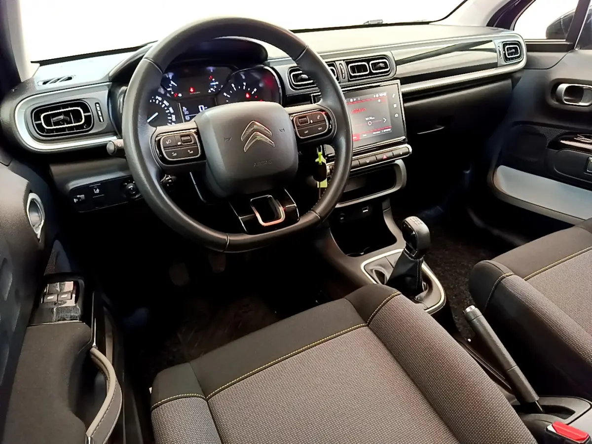 Intérieur avant de la Citroën C3 2019 gris foncé, volant cuir multifonctions et écran tactile central 7 pouces visible.