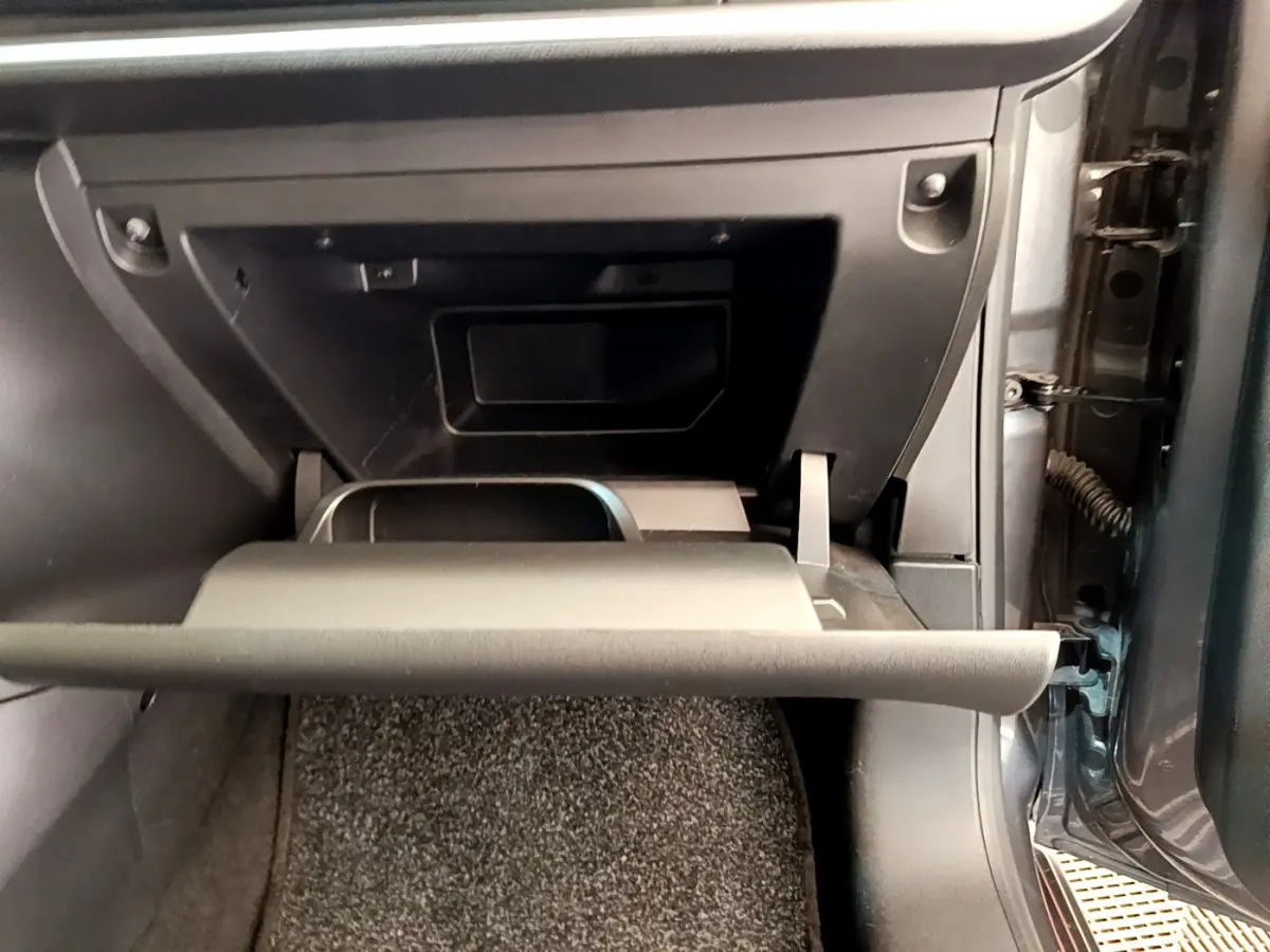 Gros plan sur la boîte à gants ouverte côté passager d'une Citroën C3 gris foncé 2019, intérieur noir.