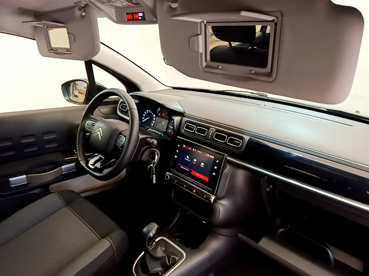 Intérieur avant droit de la Citroën C3 2019, tableau de bord noir avec écran tactile et volant multifonctions cuir.