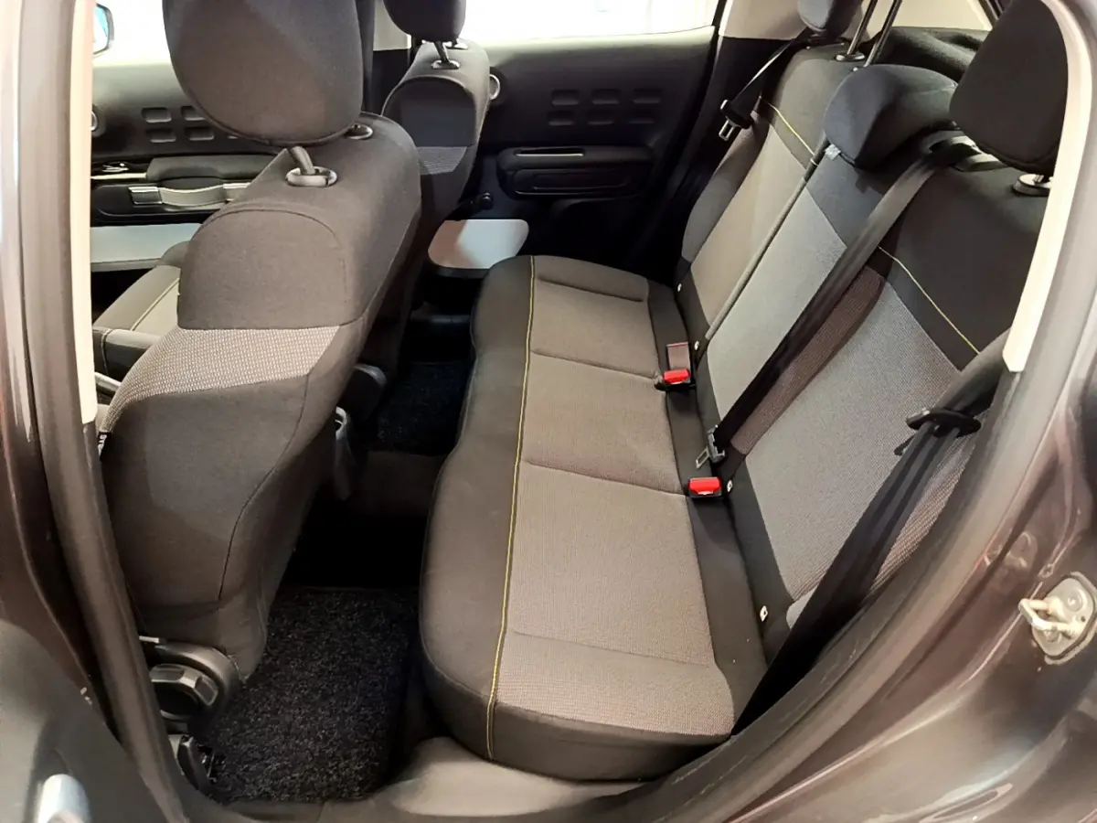 Vue intérieure côté droit sur la banquette arrière grise de la Citroën C3 PureTech 82 Shine 2019, avec ceintures visibles.