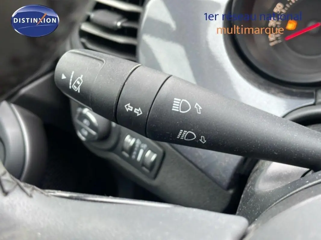 Gros plan sur la commande des phares et clignotants du Fiat 500X MY18 gris foncé, tableau de bord en arrière-plan.