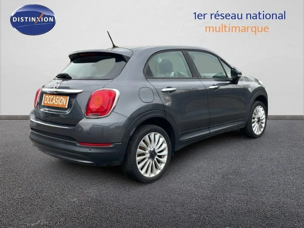 Fiat 500X gris foncé vue 3/4 arrière droit avec jantes alliage 18 pouces sur fond neutre.