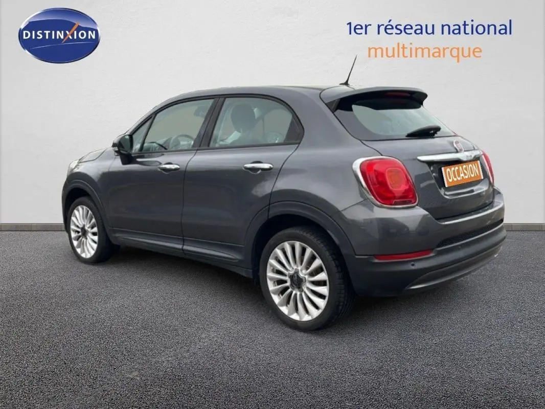 Fiat 500X gris foncé vue 3/4 arrière droit, jantes alliage 18 pouces et feux arrière rouges visibles.