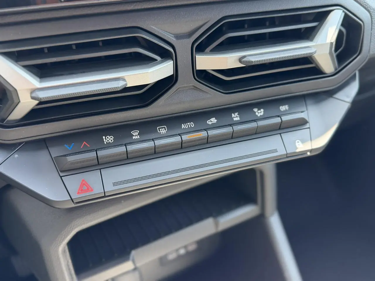 Détail des commandes de climatisation et des aérateurs hexagonaux du tableau de bord du Dacia Duster 2026.