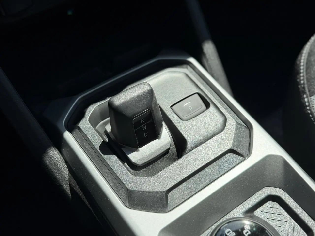 Gros plan sur la commande de boîte automatique du Dacia Duster Hybrid-G 150, finition intérieure gris anthracite.