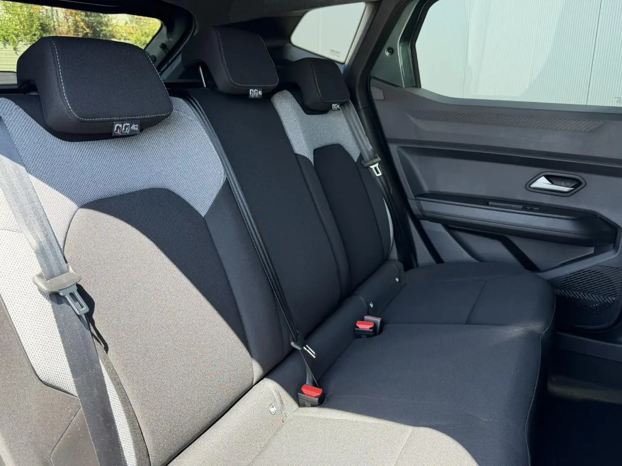 Vue côté droit des sièges arrière noirs et gris du Dacia Duster Hybrid-G 150 4X4 Journey avec ceinture et appuie-têtes.
