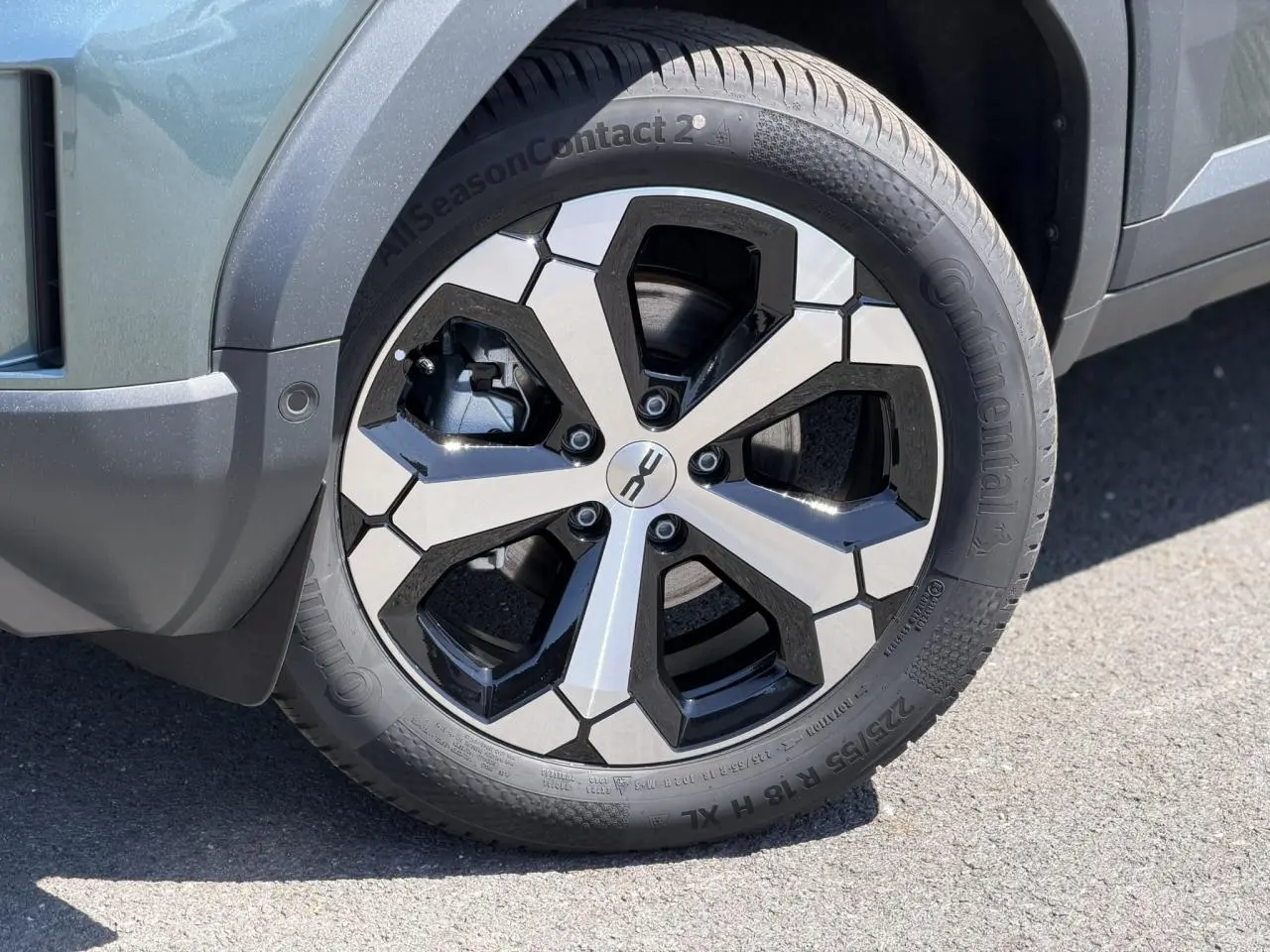 Gros plan sur la jante alliage 18 pouces noire et argent du Dacia Duster Vert Cèdre, avec pneu Continental visible côté avant droit.