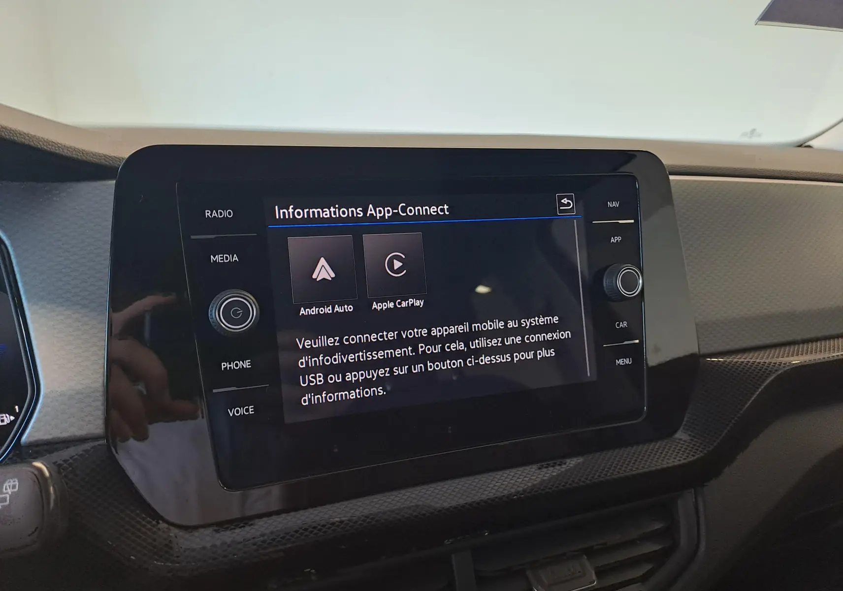 Écran tactile central du Volkswagen T-Cross 2025 affichant les options Android Auto et Apple CarPlay, intérieur noir.