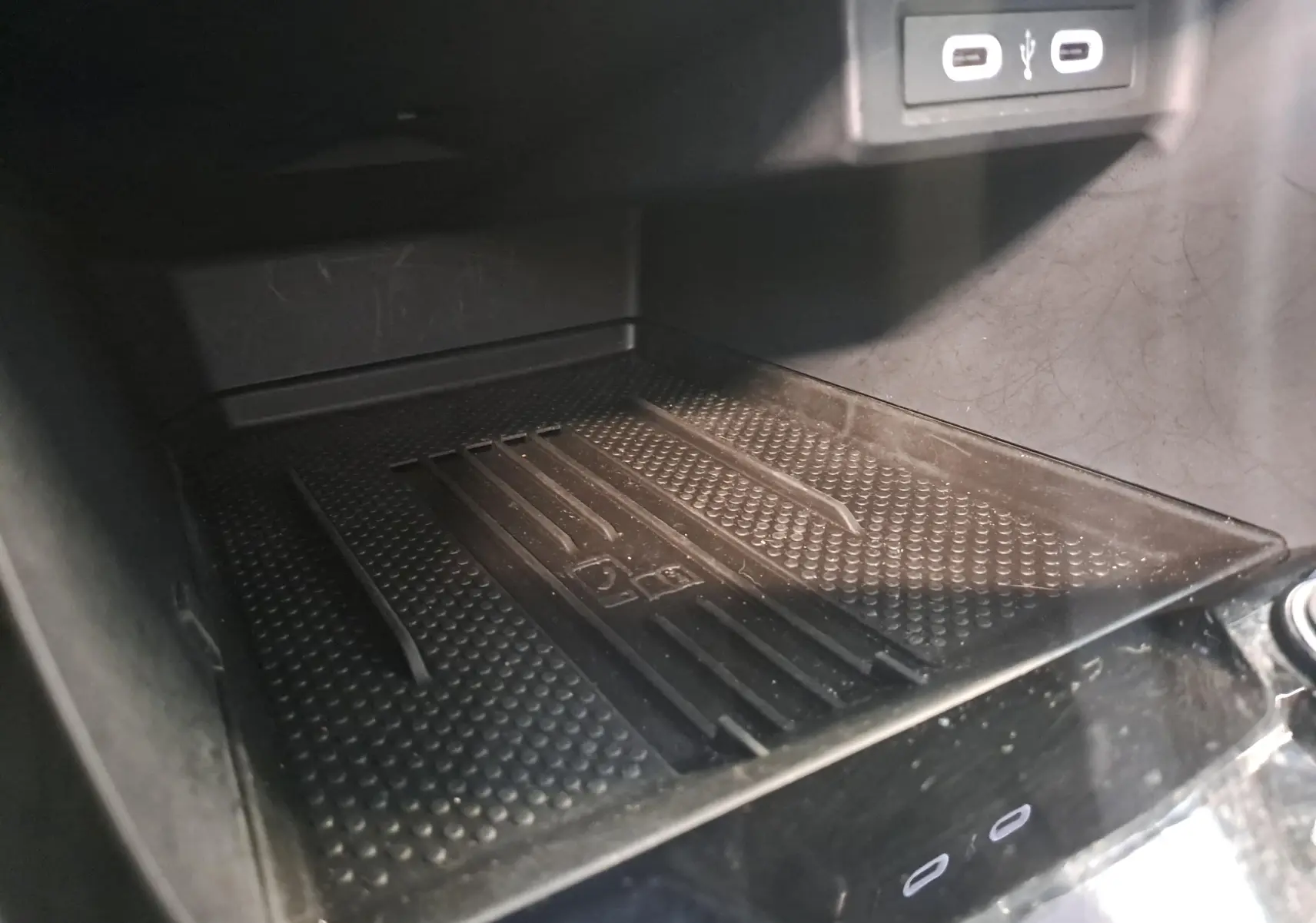 Détail de la console centrale du Volkswagen T-Cross 2025, zone de recharge sans fil avec ports USB visibles.