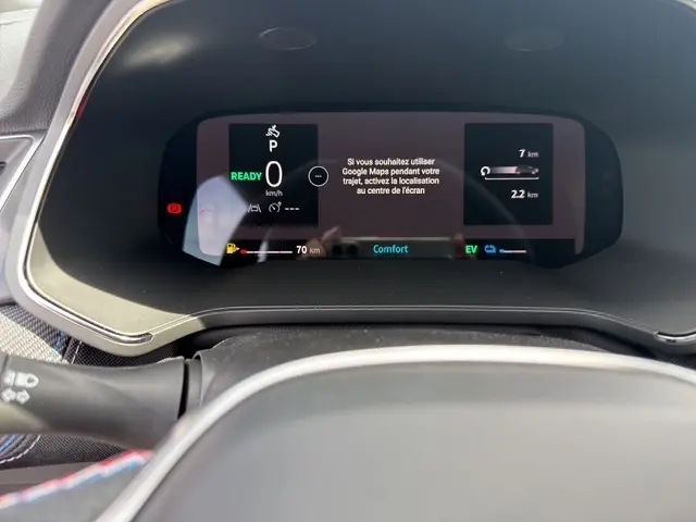 Gros plan sur le combiné d'instruments numérique de la Renault Captur blanc, affichant les informations de conduite et navigation.