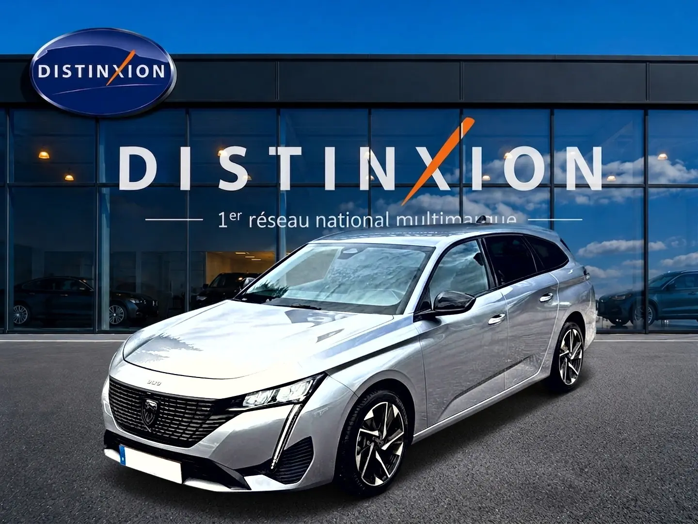 Peugeot 308 SW gris vue 3/4 avant droit, avec jantes alliage et calandre noire distinctive.