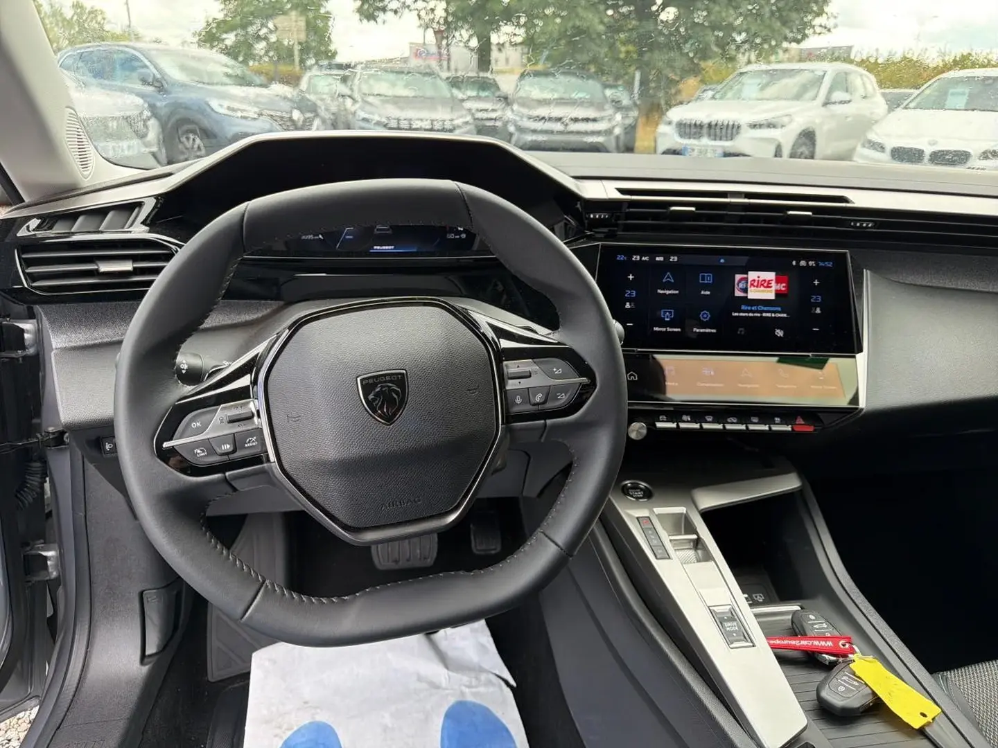 Vue intérieure centrée sur le volant multifonction et l’écran tactile du tableau de bord d’une Peugeot 308 SW 2025.