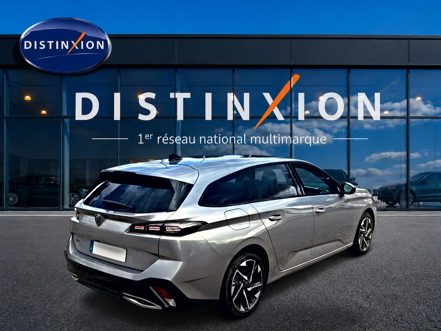Peugeot 308 SW gris vue 3/4 arrière droit, avec vitres arrière surteintées et jantes alliage distinctives.