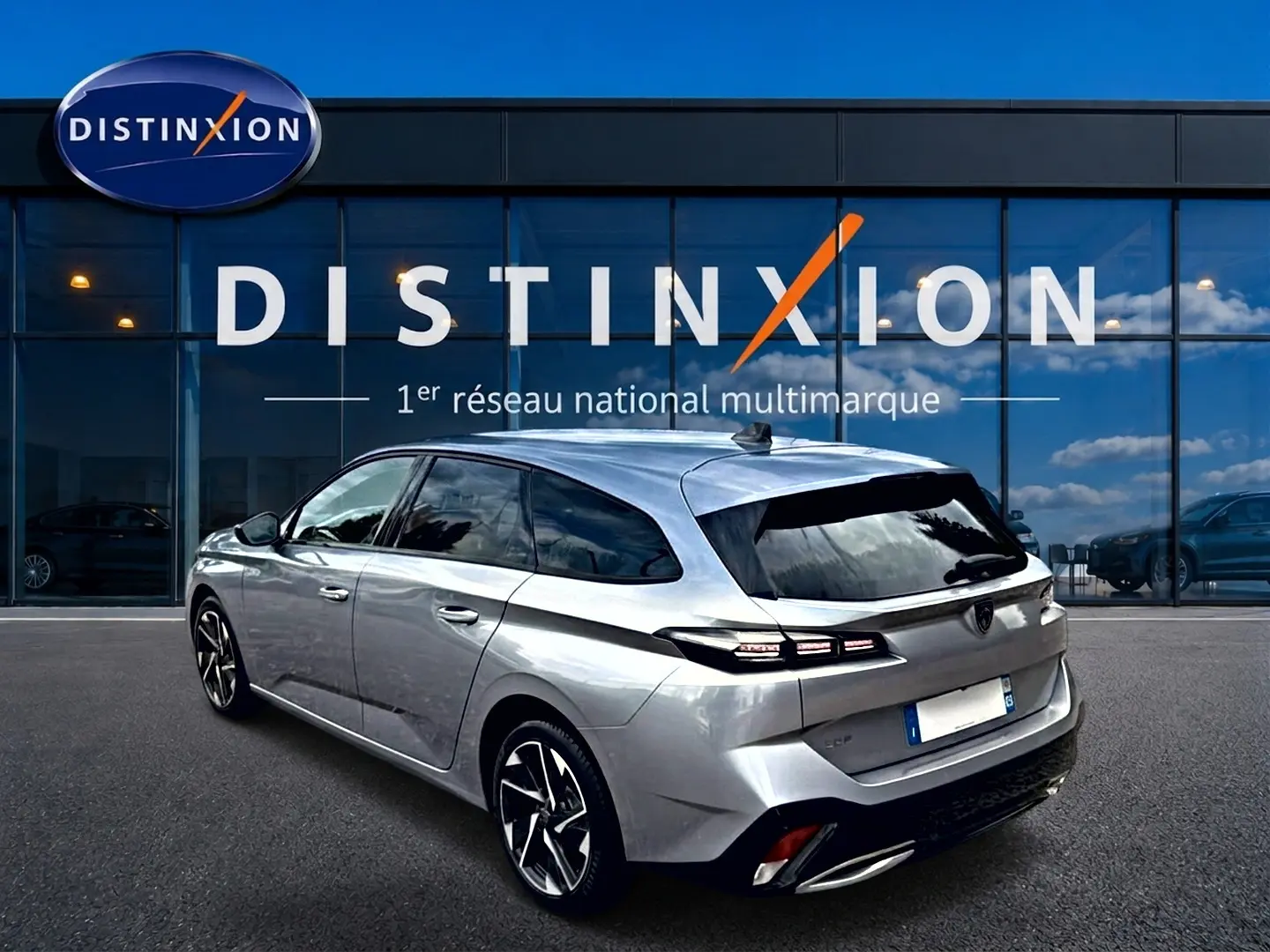 Peugeot 308 SW gris en 3/4 arrière droit, avec vitres surteintées et jantes alliage distinctives.