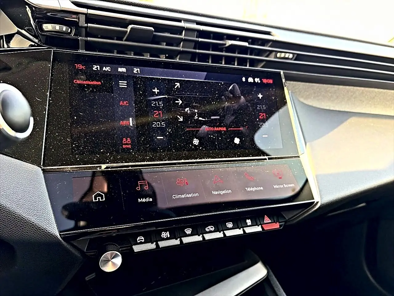 Vue rapprochée de la console centrale tactile de la Peugeot 408 Hybrid 145 allure, affichant la climatisation.