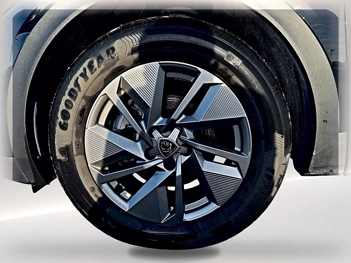 Gros plan sur la roue avant droite d'une Peugeot 408 Hybrid 145 allure e-dcs6 noire, jante alu au design moderne.