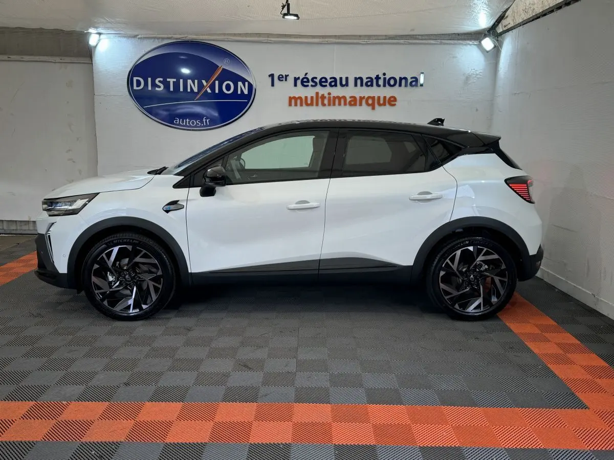 Profil droit d'un Renault Captur blanc esprit Alpine E-Tech 145 hybride, avec toit noir et jantes noires stylisées.