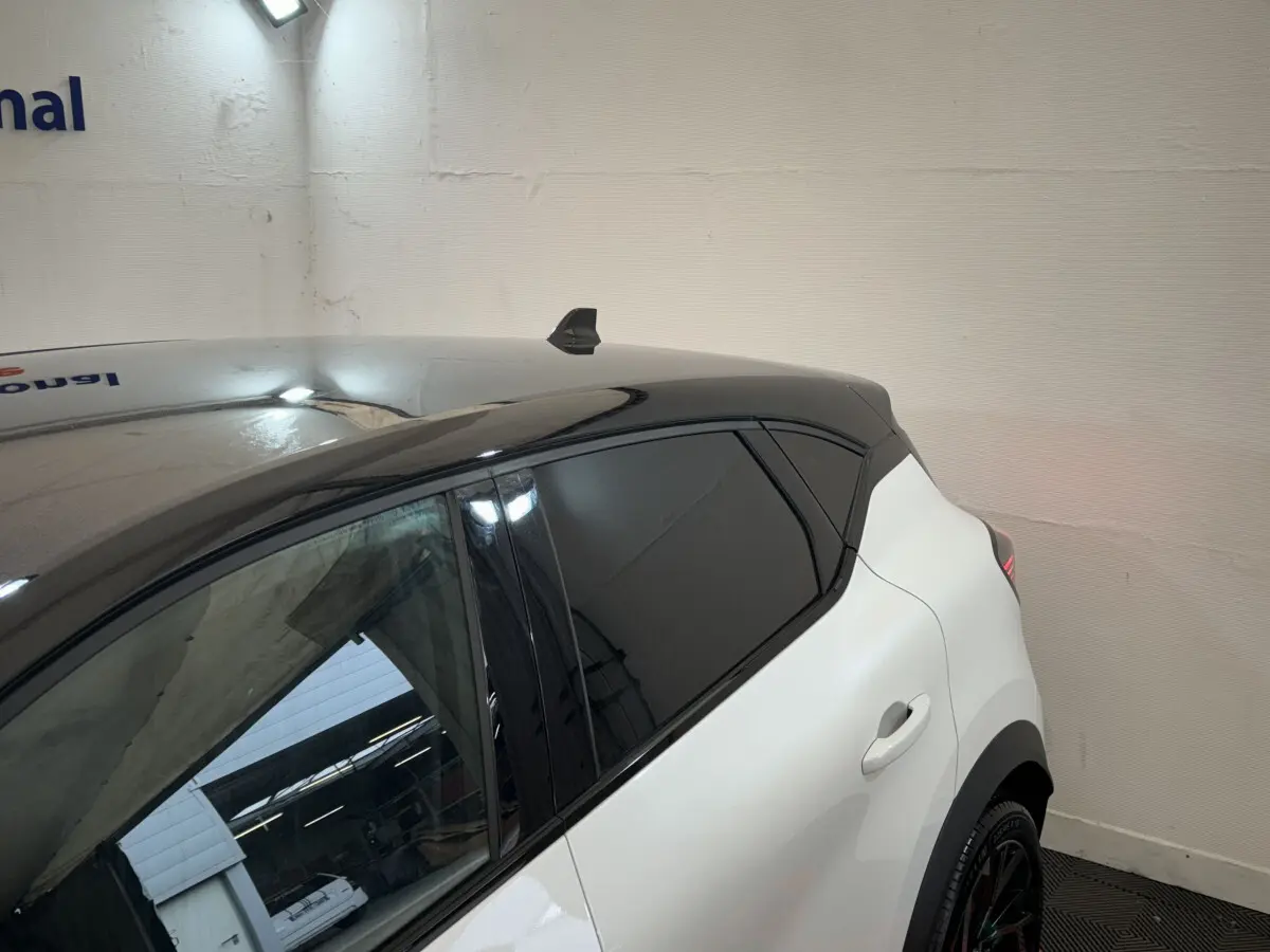 Vue 3/4 arrière droite du Renault Captur blanc avec toit noir et vitres teintées, version Esprit Alpine E-Tech.