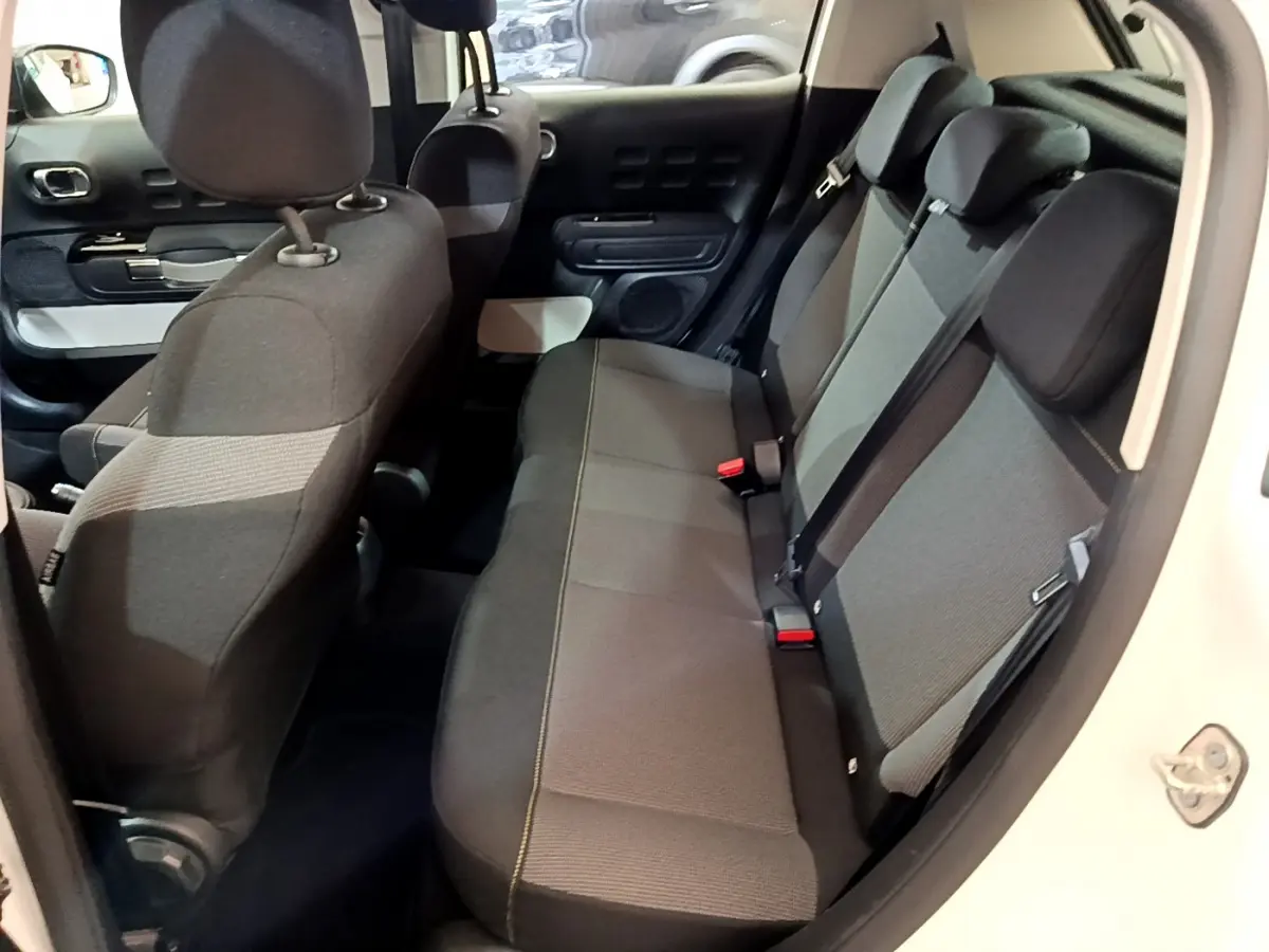 Vue intérieure côté droit montrant la banquette arrière grise de la Citroën C3 blanche de 2019.