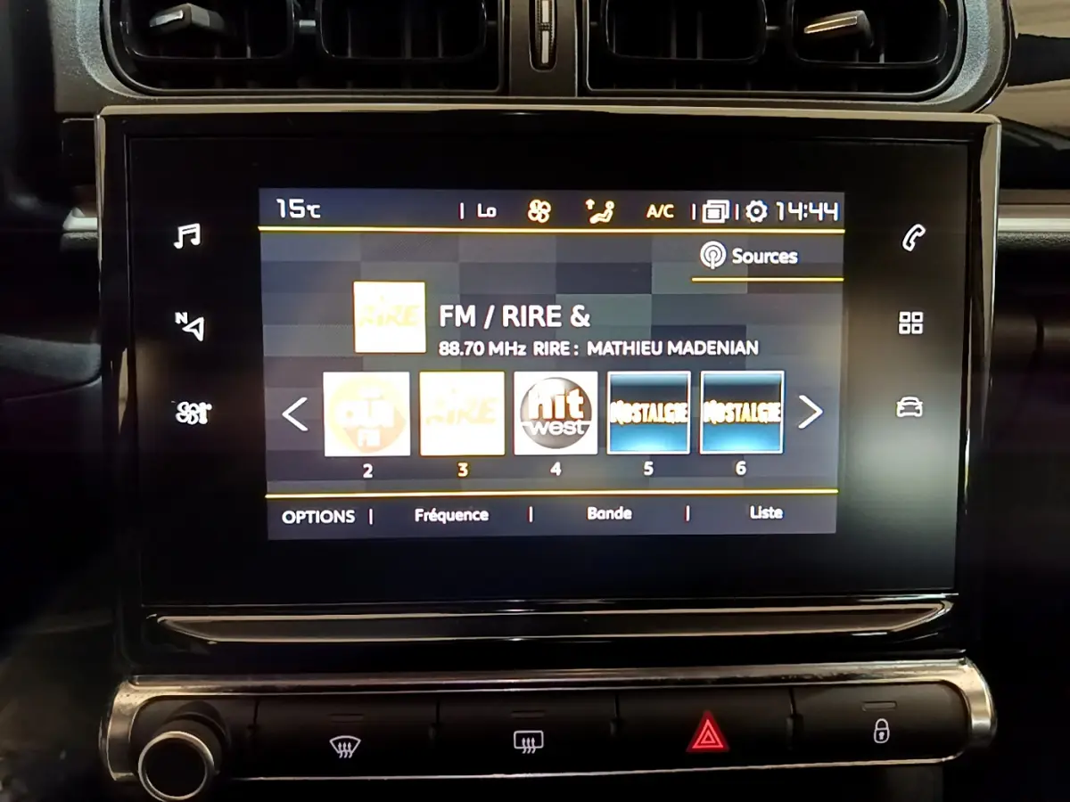 Écran tactile central de la CITROEN C3 blanche 2019 affichant les stations radio FM avec commandes climatisation en dessous.