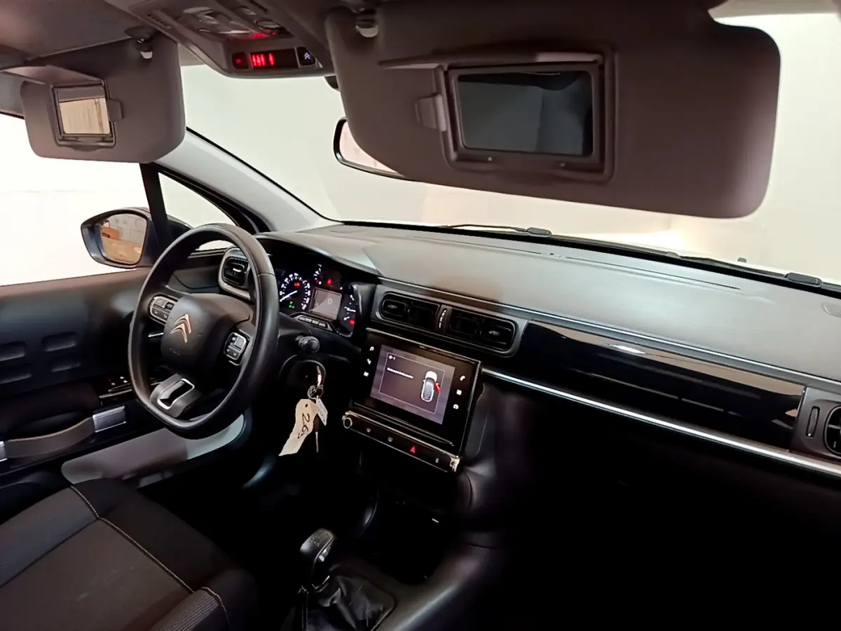Vue intérieure côté conducteur de la Citroën C3 2019 avec tableau de bord noir et écran tactile central allumé.