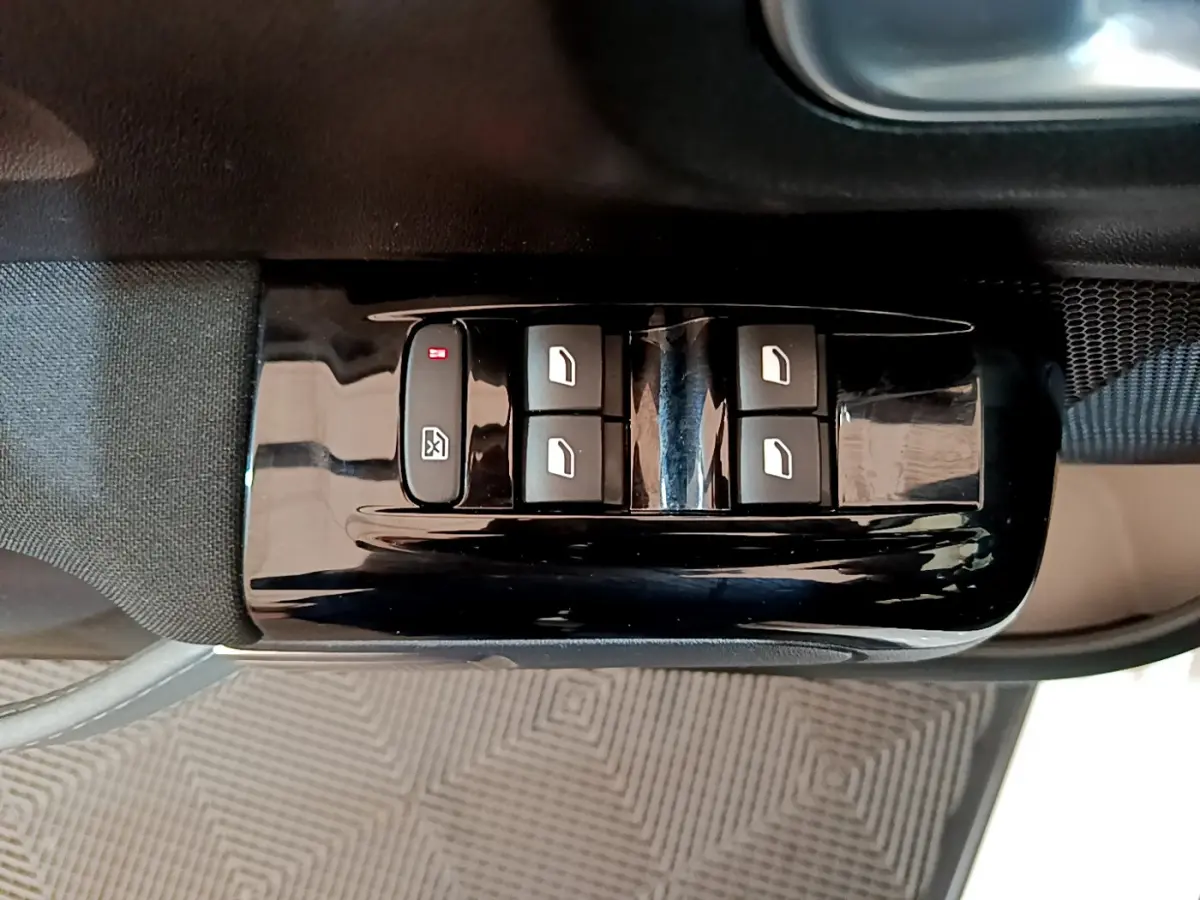 Gros plan sur les commandes des vitres électriques côté conducteur d'une Citroën C3 blanche, finition Feel Business.