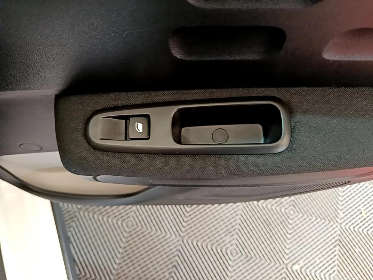 Gros plan sur la commande de lève-vitre côté gauche de la porte intérieure d'une Citroën C3 blanche de 2019.