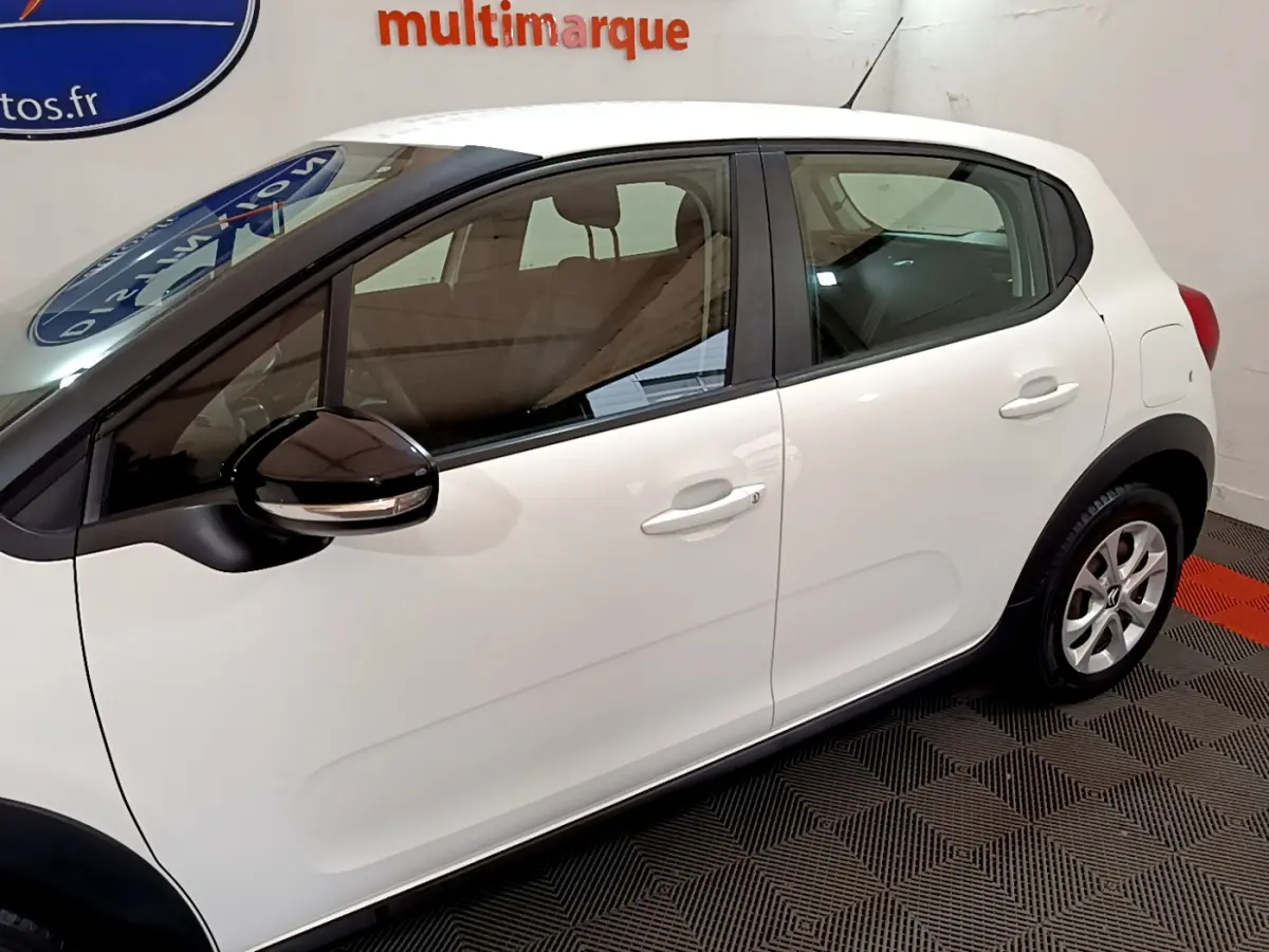 Profil côté gauche d'une Citroën C3 blanche 2019 avec rétroviseur noir et poignées de porte assorties.