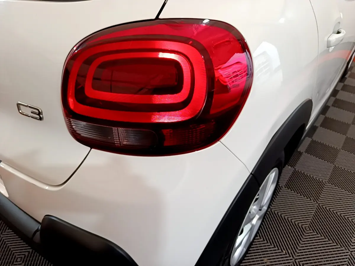 Gros plan sur le feu arrière droit d'une Citroën C3 blanche de 2019, avec logo C3 visible sur la carrosserie.