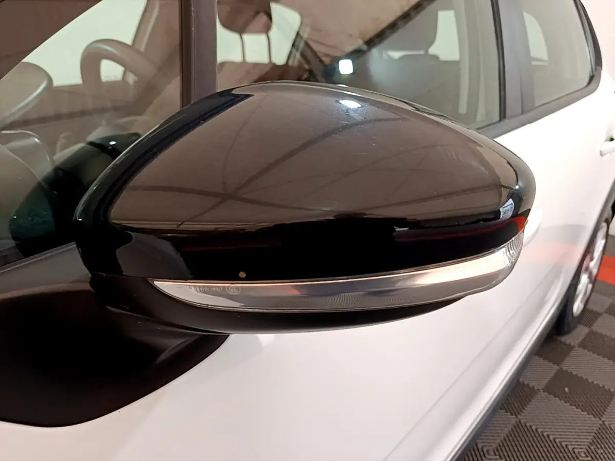 Rétroviseur noir avec clignotant intégré côté gauche d'une Citroën C3 blanche vue en gros plan.
