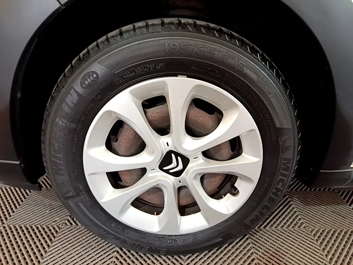 Gros plan sur la roue avant droite d'une Citroën C3 blanche, mettant en valeur la jante et le logo Citroën central.