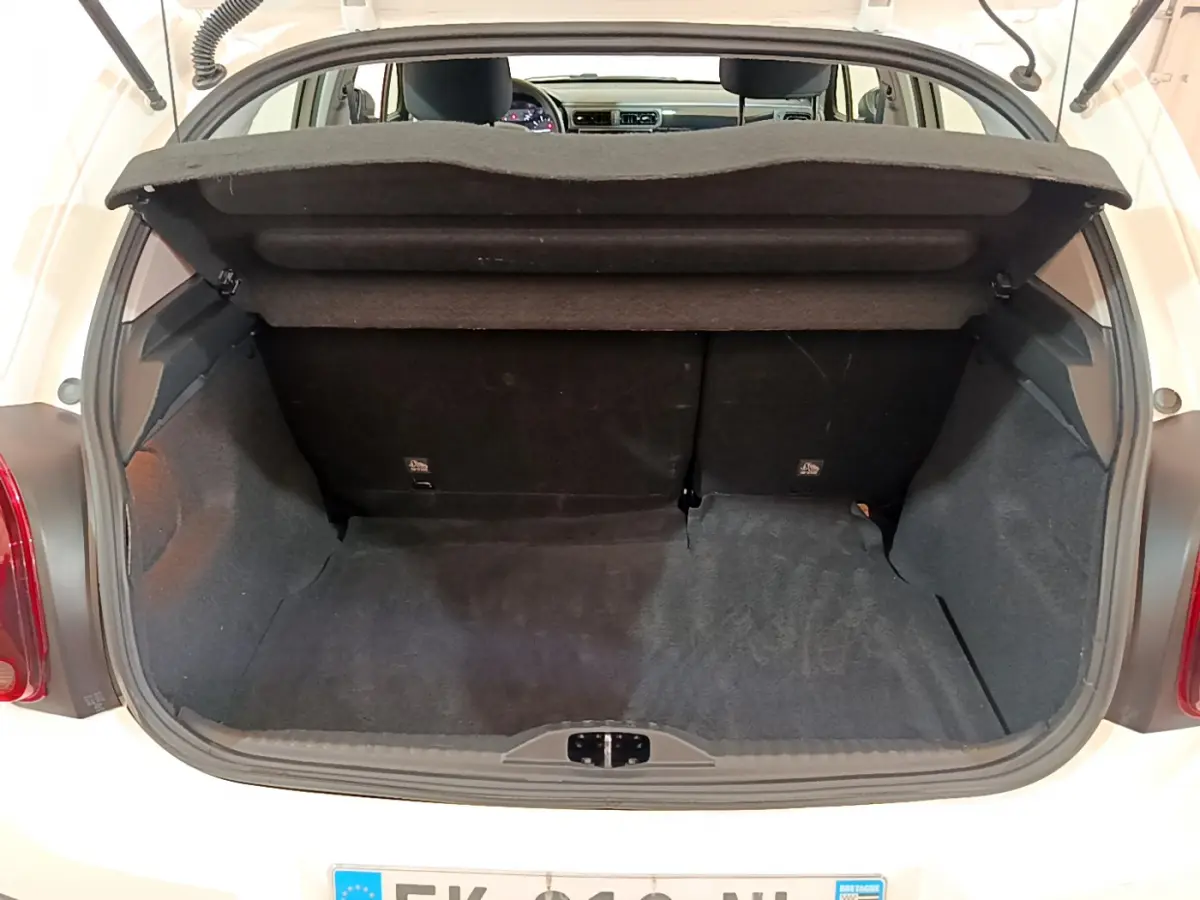 Coffre ouvert vu de l'arrière d'une Citroën C3 blanche de 2019, montrant l'espace de chargement vide et la tablette arrière.