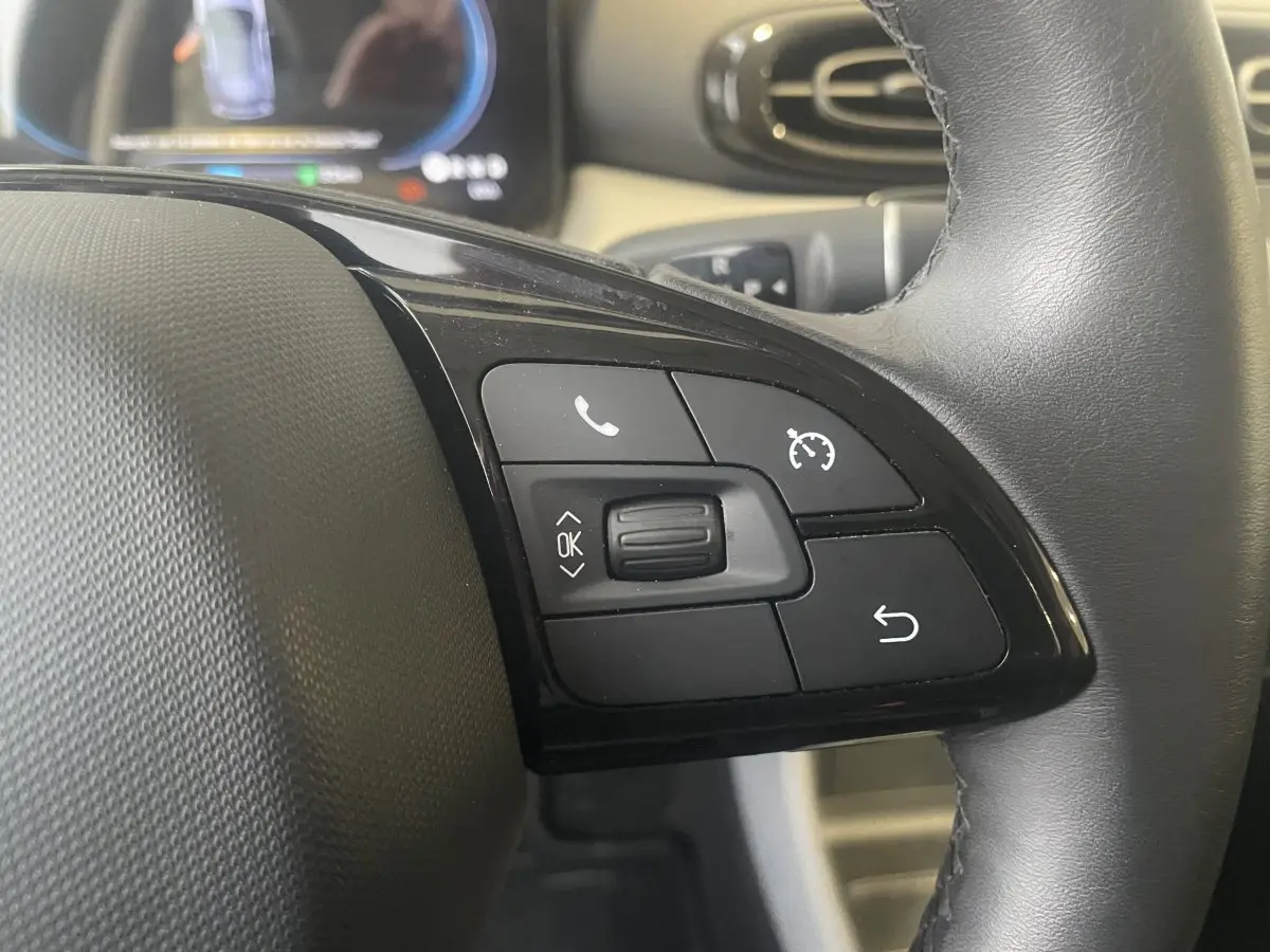 Gros plan sur le côté droit du volant cuir noir du LEAPMOTOR T03 Luxury 2025 avec commandes multifonctions.