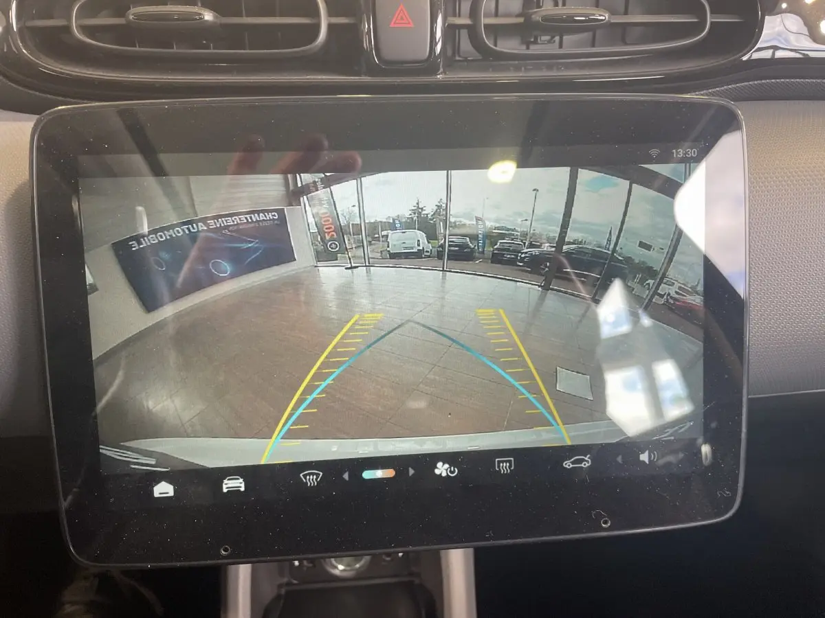 Écran tactile central du Leapmotor T03 Luxury blanc montrant la caméra de recul avec guidage de trajectoire.