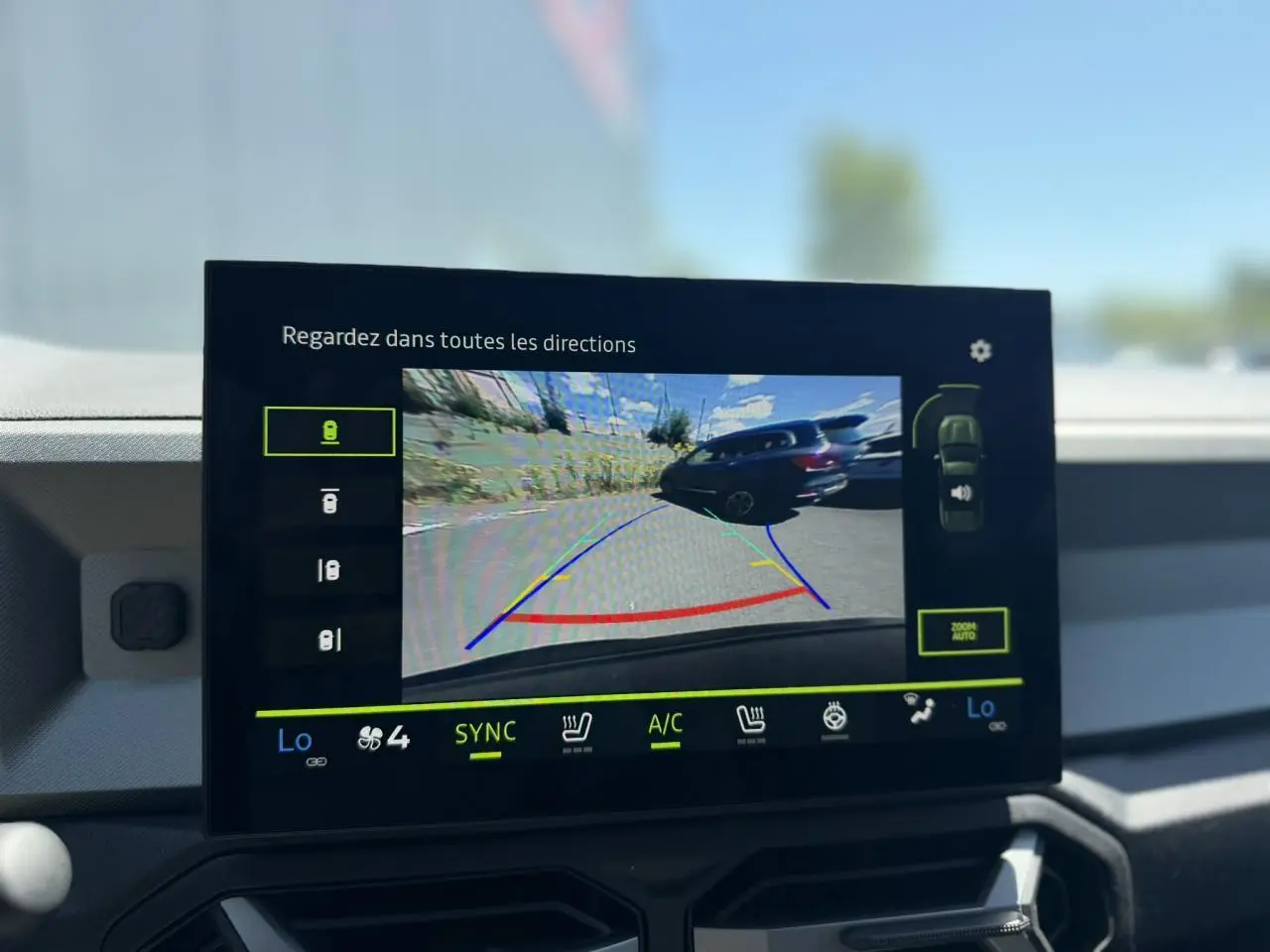 Écran tactile intérieur montrant la caméra de recul du Dacia Bigster Hybrid-G 150 4X4 en bleu indigo.