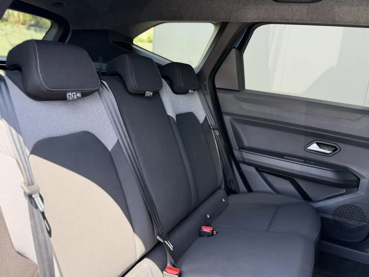 Vue latérale droite de la banquette arrière noire et grise du Dacia Bigster 2026 avec ceintures et appuie-têtes intégrés.