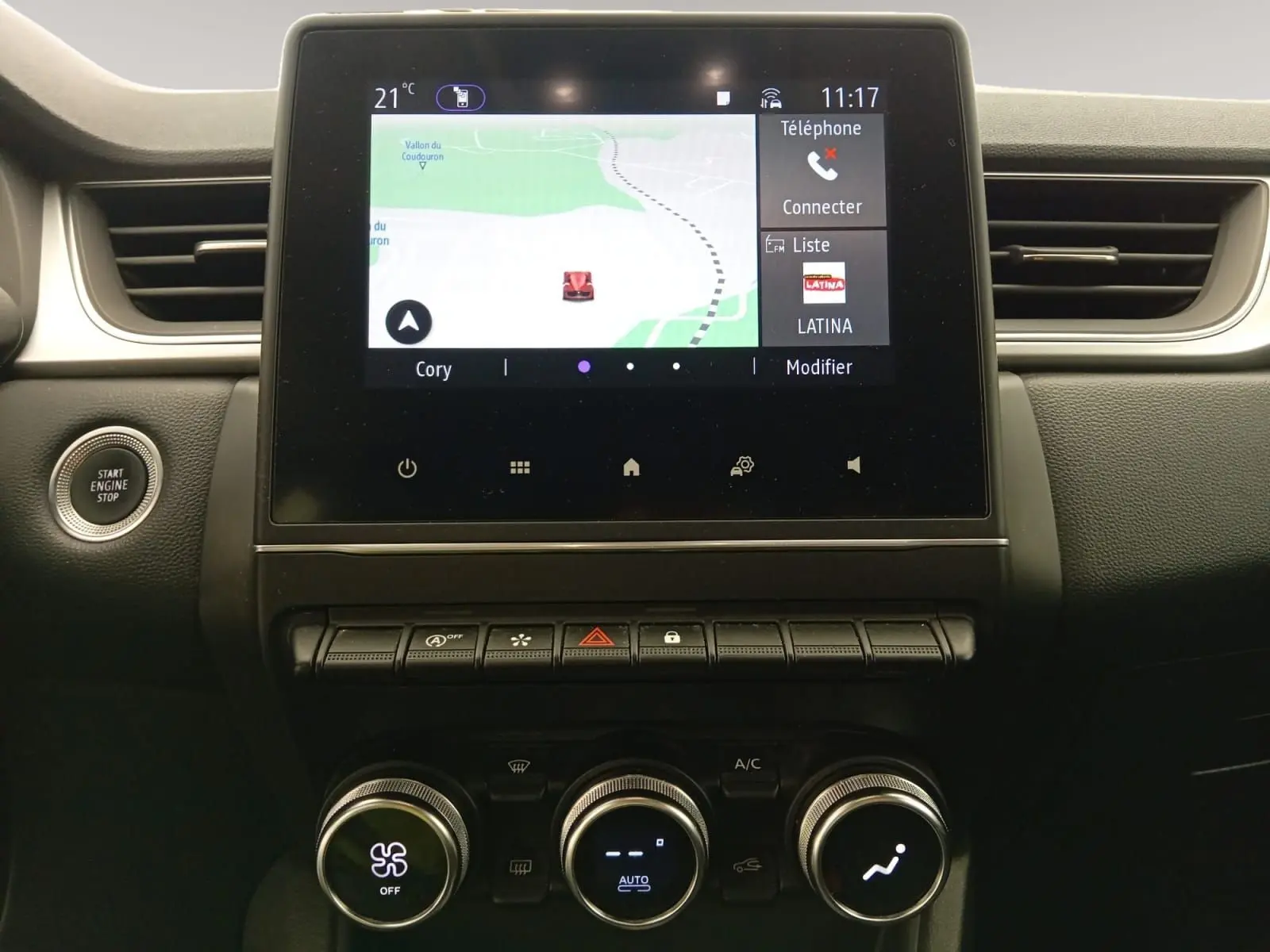 Vue rapprochée de la console centrale du Renault Captur 2023, écran tactile avec navigation et commandes de climatisation.