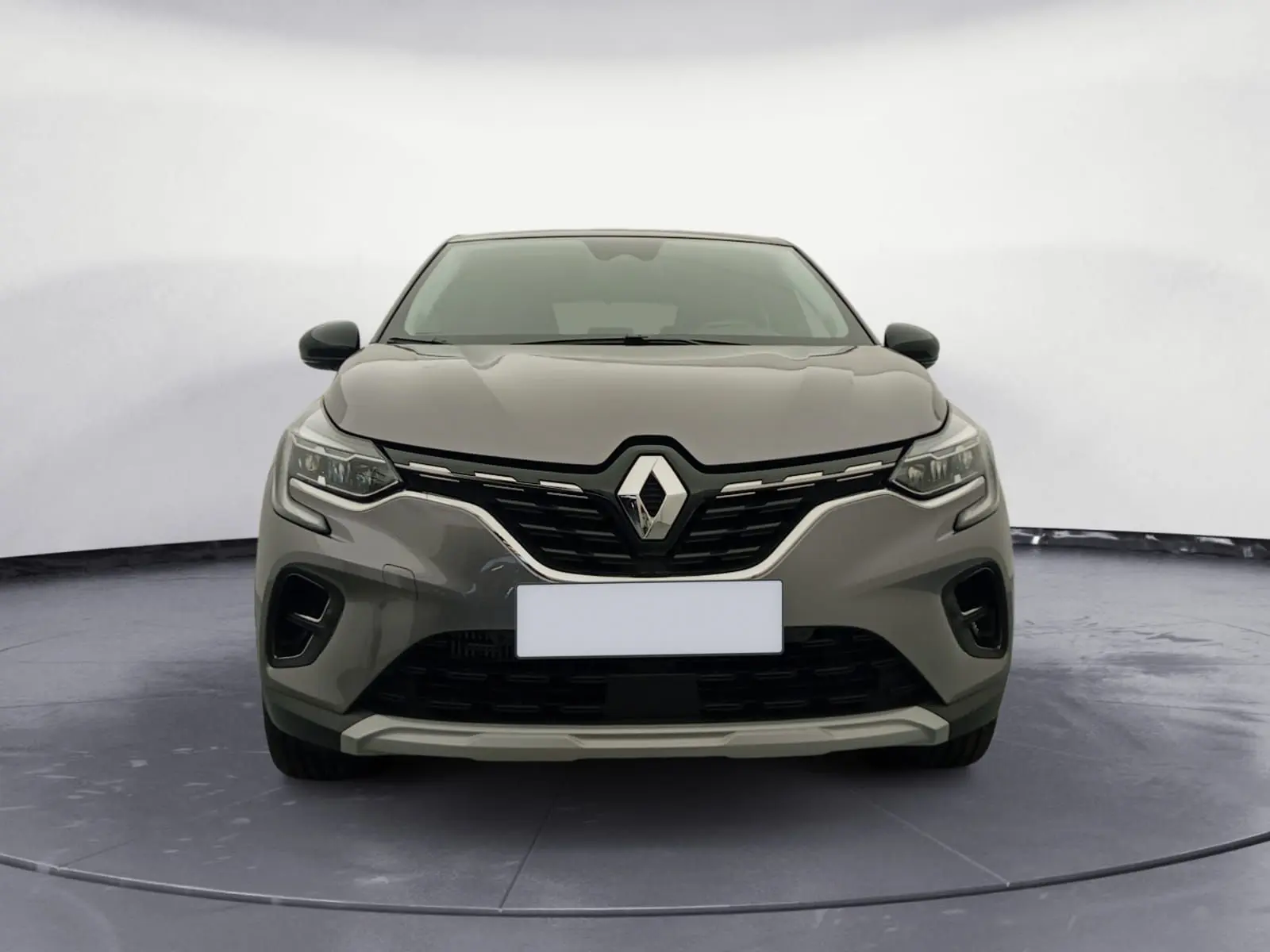 Vue frontale du Renault Captur 1.3 Mild Hybrid 140 Techno en gris Cassiopée avec toit noir, mettant en valeur sa calandre distinctive.