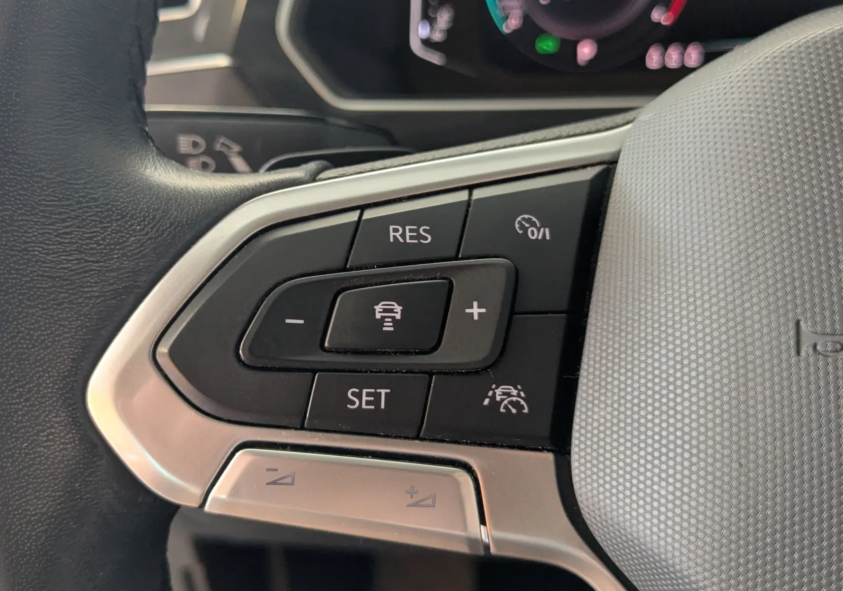 Gros plan sur les commandes de régulateur de vitesse au volant cuir noir du Volkswagen Tiguan 2.0 TDI 2021.