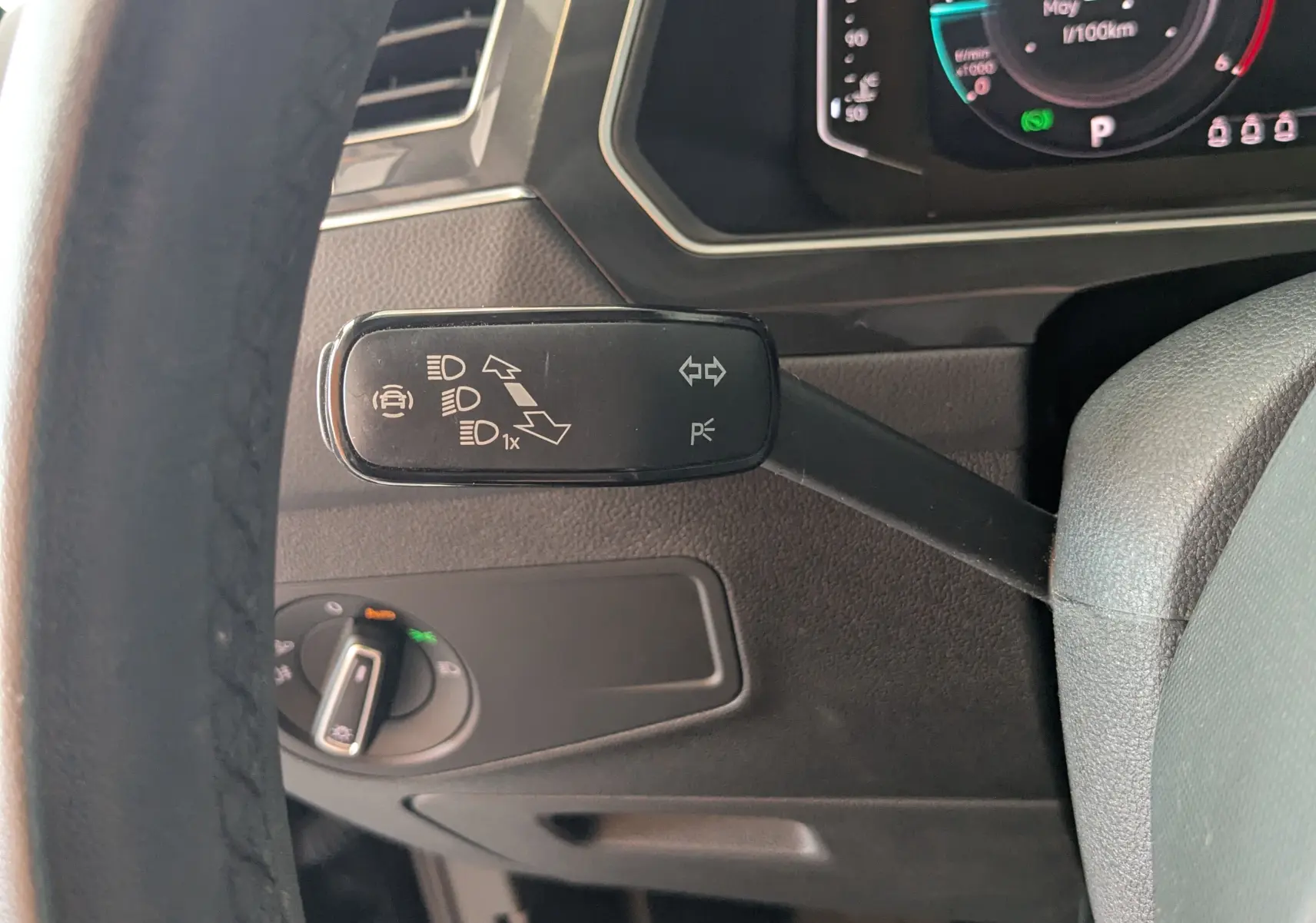 Gros plan sur la manette de clignotant noire à gauche du volant dans l’habitacle du Volkswagen Tiguan noir 2021.