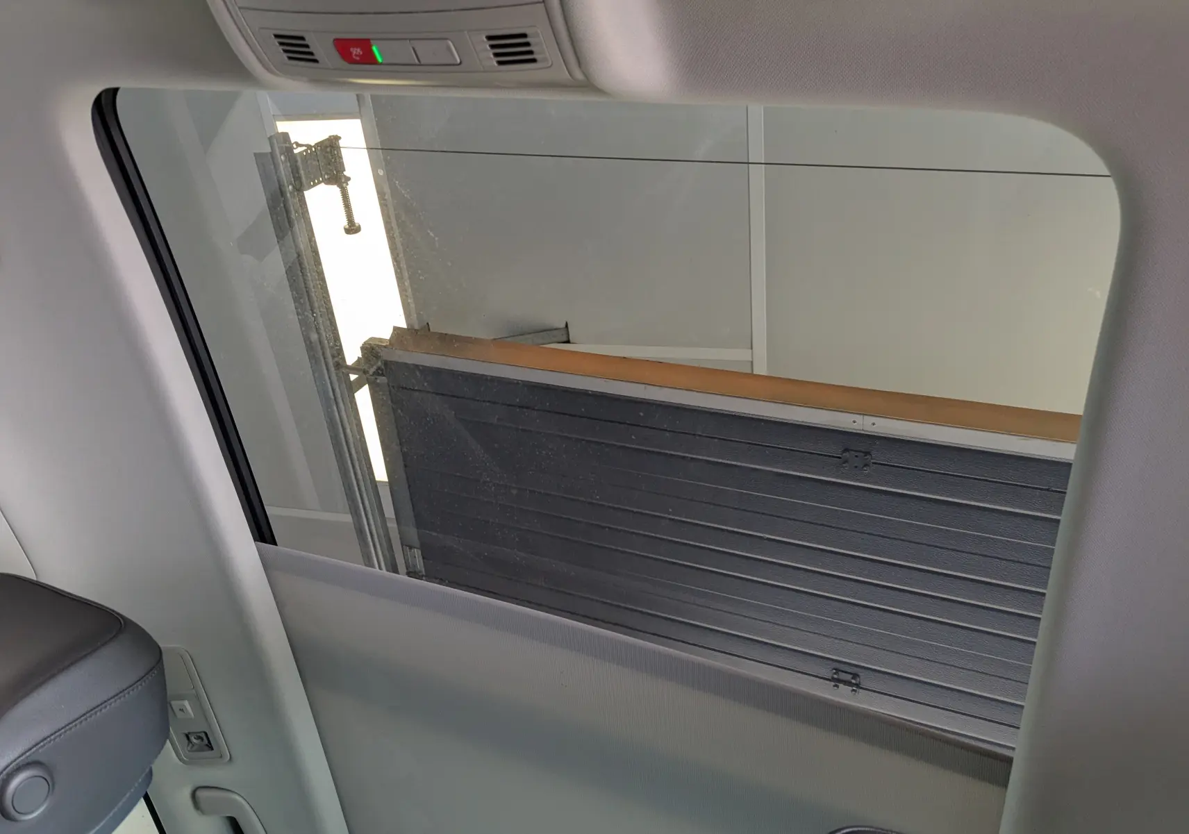 Vue intérieure sur la vitre latérale droite du Volkswagen Tiguan noir, avec partie du siège et garniture visibles.