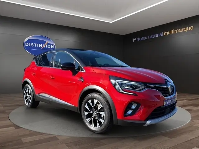 Renault Captur Techno TCe 90 rouge vue 3/4 avant, avec jantes alliage et toit noir brillant dans showroom.