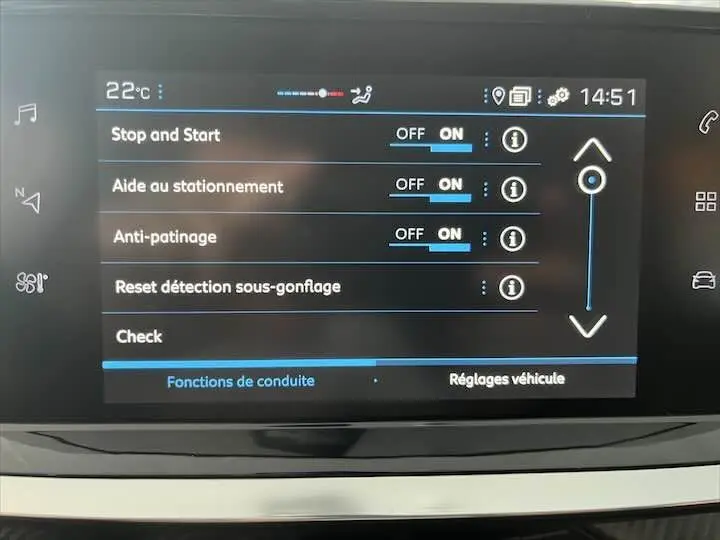 Écran tactile du tableau de bord de la Peugeot 208 affichant les réglages d'aides à la conduite en mode jour.