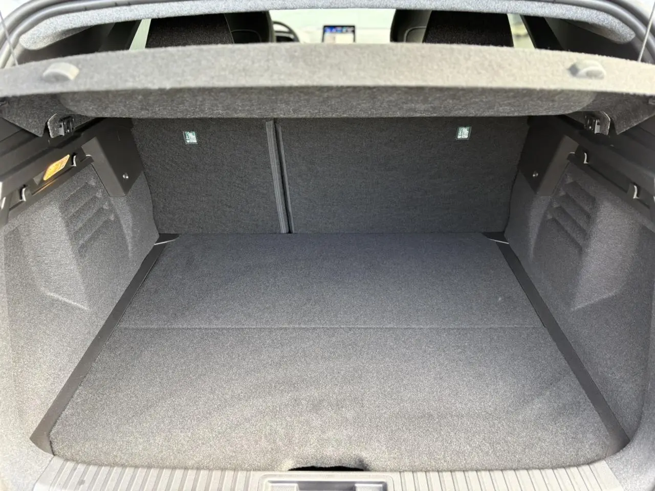 Coffre ouvert vu de l'arrière d'une Renault SYMBIOZ gris Rafale, montrant un espace de chargement propre et spacieux.