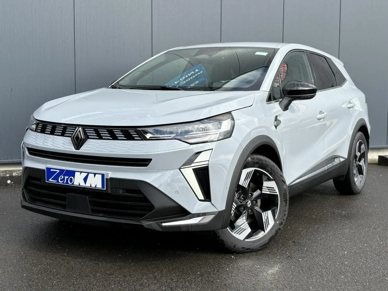 Vue 3/4 avant d'un Renault Symbioz gris Rafale avec calandre noire et jantes au design moderne.