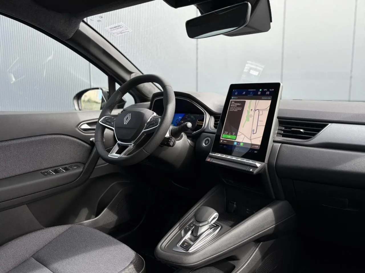Intérieur avant droit du Renault SYMBIOZ gris, volant multifonction et écran tactile GPS vertical visible