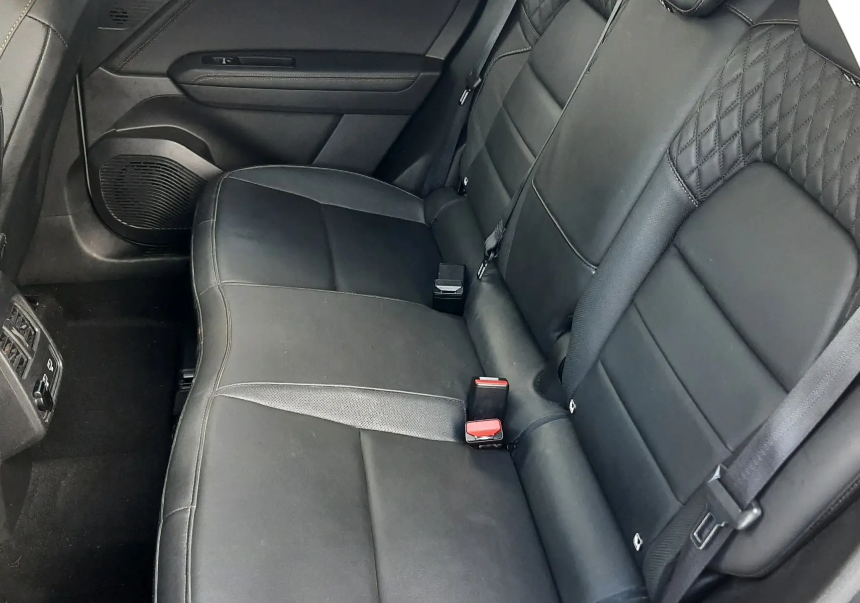 Vue intérieure côté droit des sièges arrière en cuir noir du Renault Captur 2020, soulignant les finitions élégantes et les ceintures de sécurité.