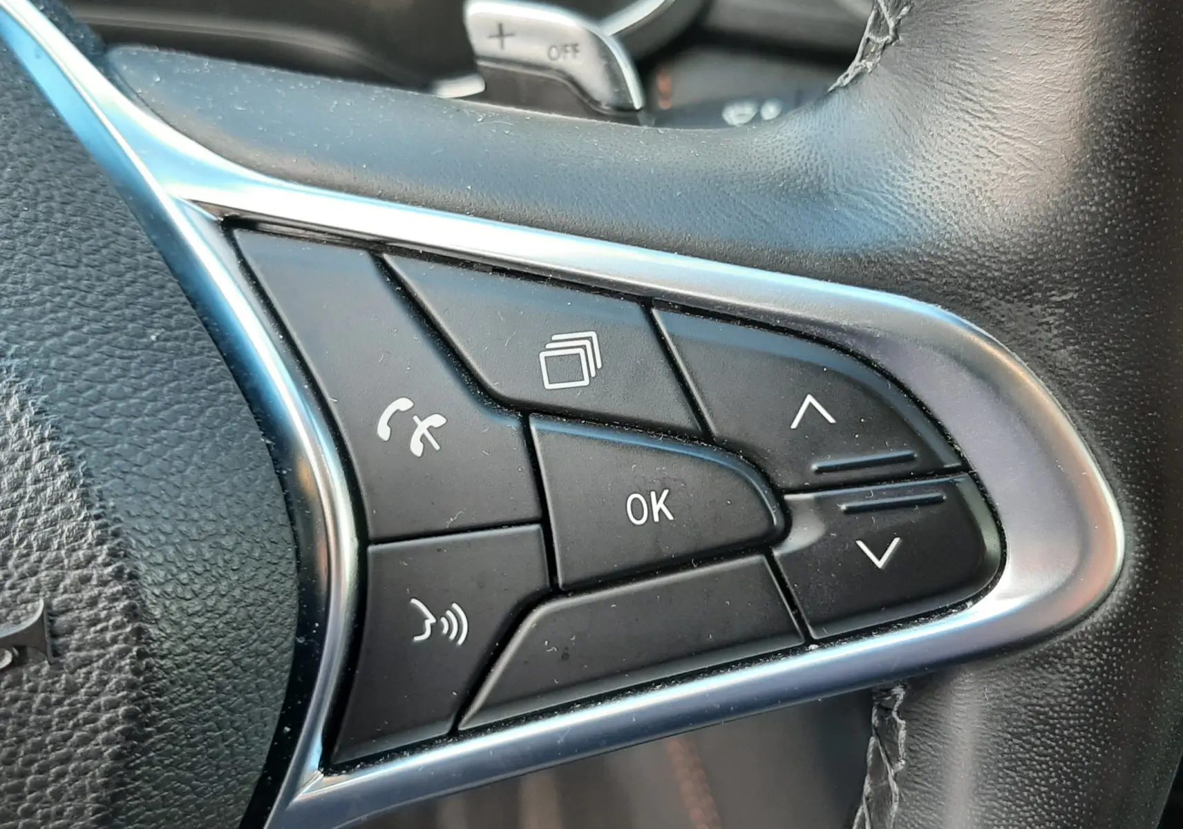 Gros plan sur les commandes multifonctions noires à droite du volant cuir du Renault Captur blanc toit noir 2020.