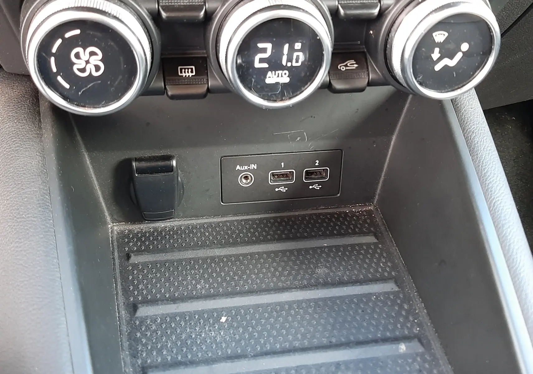 Gros plan sur la console centrale du Renault Captur 2020, montrant les commandes de climatisation et ports USB.